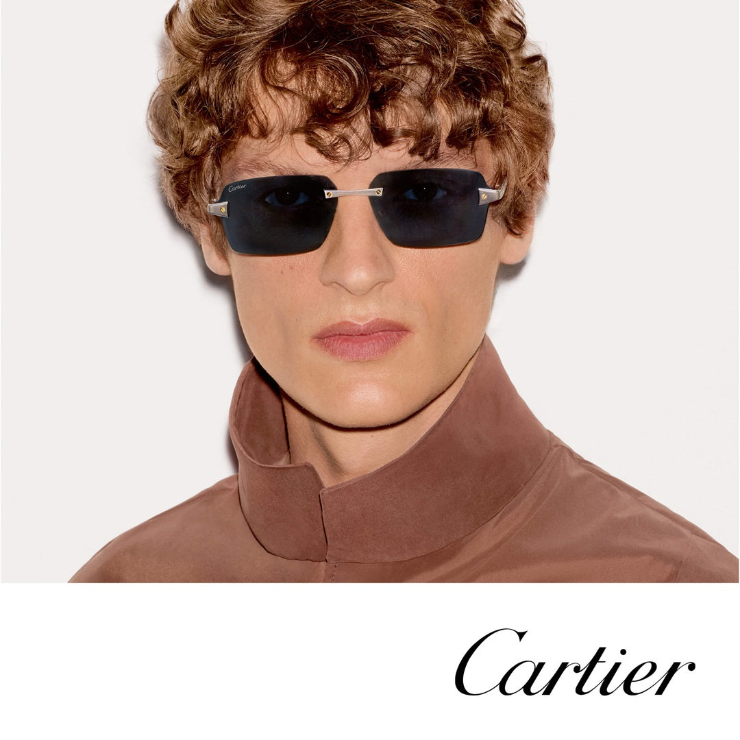 A model wearing Cartier rimless sunglasses with dark lenses and silver metal temples.